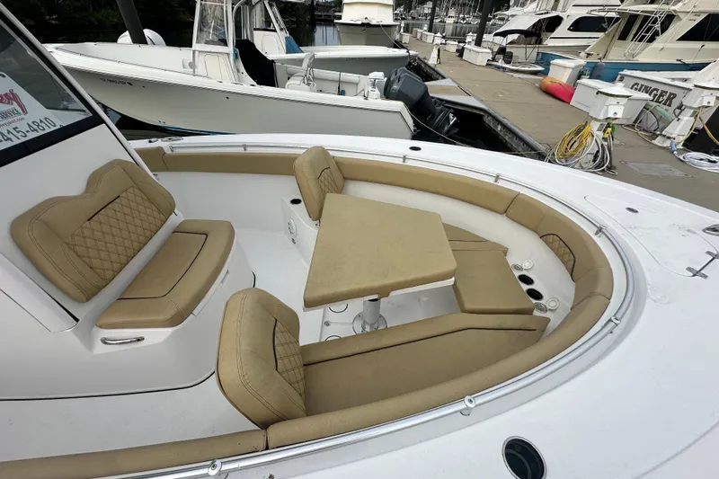  Yacht Photos Pics 2023 Sportsman Open 282 Center Console boat with tan seating and table at marina.