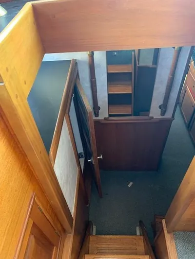 Duc De Kent Yacht Photos Pics Interior view of 1985 Custom Cape Island Trawler 43, featuring wooden stairs and hallway.