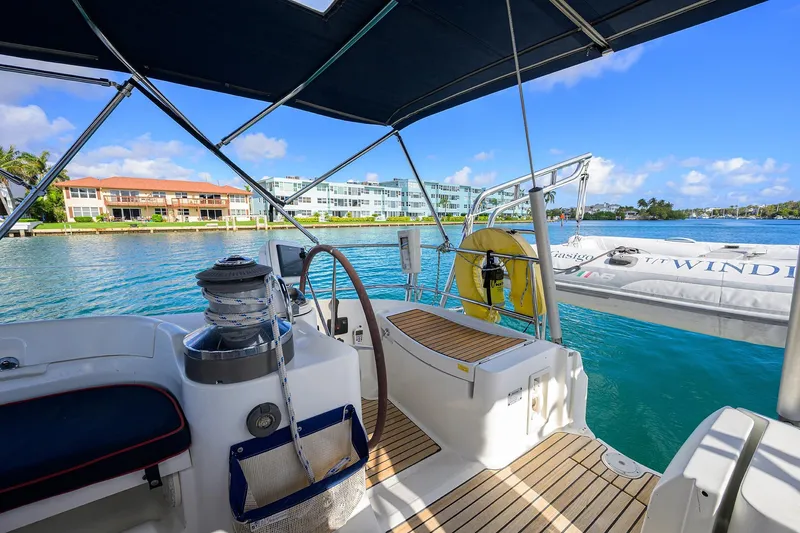 Windigo Yacht Photos Pics Cockpit view of 2003 Beneteau 50 yacht, overlooking serene waterfront and modern buildings.
