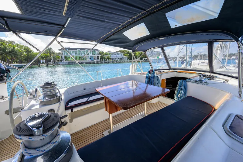 Windigo Yacht Photos Pics Beneteau 50 sailboat cockpit, 2003 model, with seating and table, docked by waterfront homes.