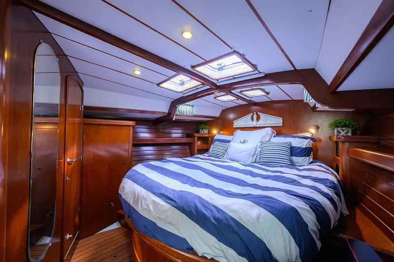 Windigo Yacht Photos Pics Luxurious cabin interior of 2003 Beneteau 50 yacht with striped bedding and wooden finish.