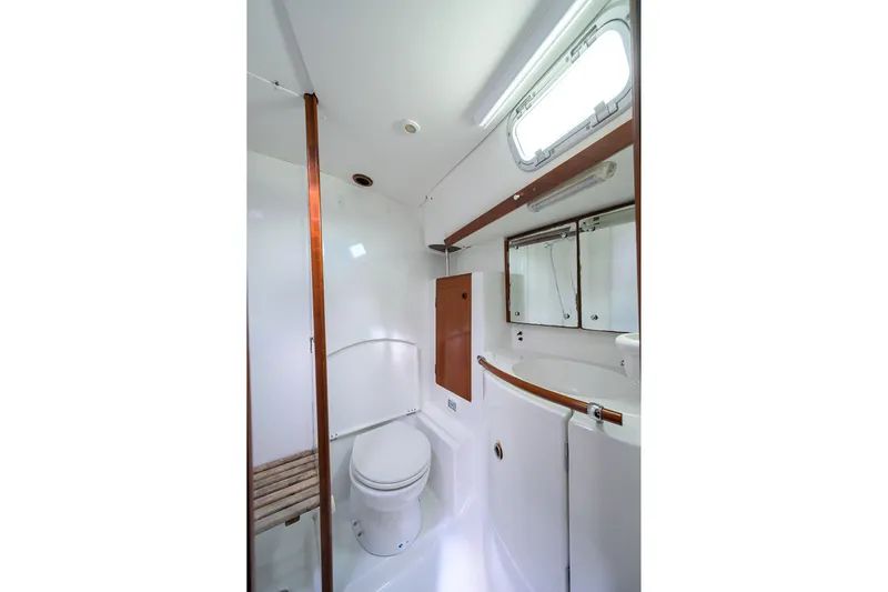 Windigo Yacht Photos Pics Bathroom interior of 2003 Beneteau 50 yacht, featuring toilet, sink, and mirror.