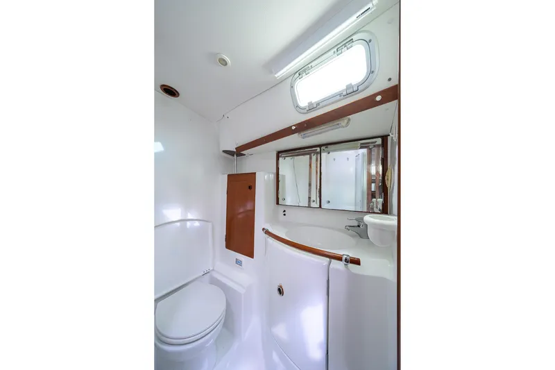 Windigo Yacht Photos Pics Bathroom interior of 2003 Beneteau 50 yacht, featuring sink, toilet, and mirror.