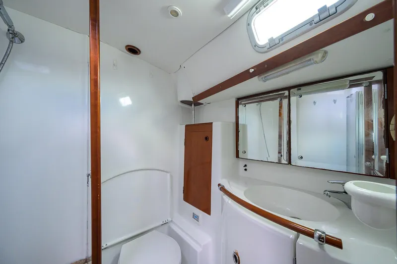 Windigo Yacht Photos Pics Bathroom interior of 2003 Beneteau 50 yacht, featuring sink, mirror, and toilet.