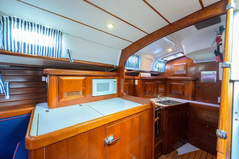 Windigo Yacht Photos Pics Interior of 2003 Beneteau 50 yacht, featuring a wooden kitchen with microwave and sink.