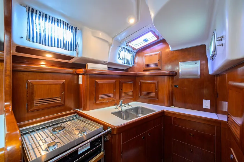 Windigo Yacht Photos Pics Luxurious 2003 Beneteau 50 yacht kitchen with wood cabinetry and modern appliances.