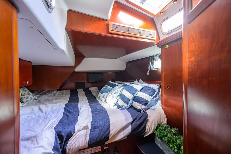 Windigo Yacht Photos Pics Cozy cabin interior of 2003 Beneteau 50 yacht with striped bedding and wooden finish.