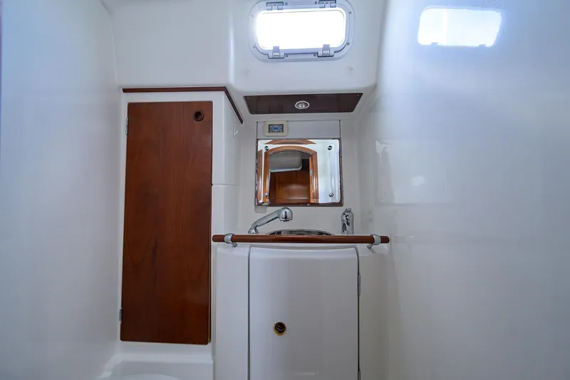 Windigo Yacht Photos Pics Beneteau 50 yacht bathroom, 2003 model, featuring wooden cabinetry and compact sink.