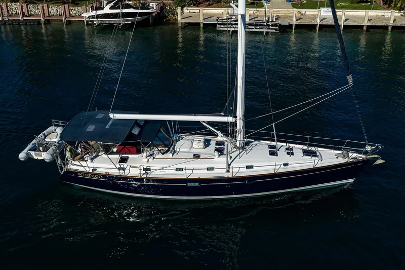 Windigo Yacht Photos Pics 2003 Beneteau 50 sailboat on water, side view, with dock and greenery in background.