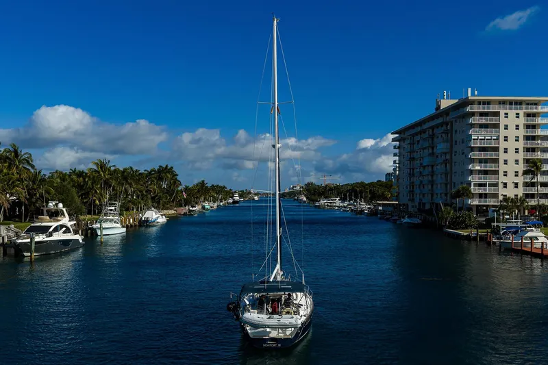Windigo Yacht Photos Pics Sailboat Beneteau 50 (2003) cruising a scenic canal with palm trees and buildings.