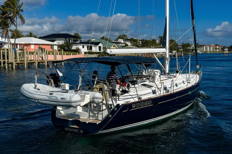 Windigo Yacht Photos Pics Sailing yacht Beneteau 50, 2003 model, cruising near waterfront homes under a clear blue sky.