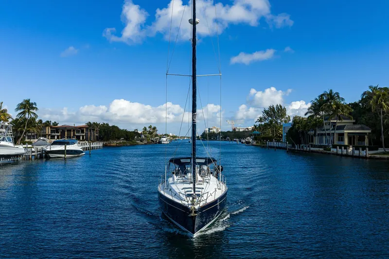 Windigo Yacht Photos Pics Sailing yacht Beneteau 50 (2003) cruising through a scenic waterway with palm trees.