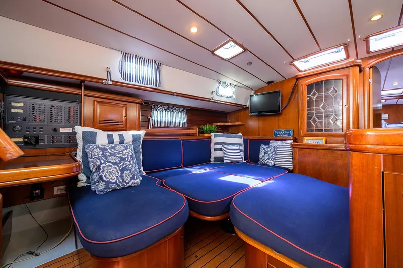 Windigo Yacht Photos Pics Luxurious interior of 2003 Beneteau 50 yacht with blue seating and wooden accents.