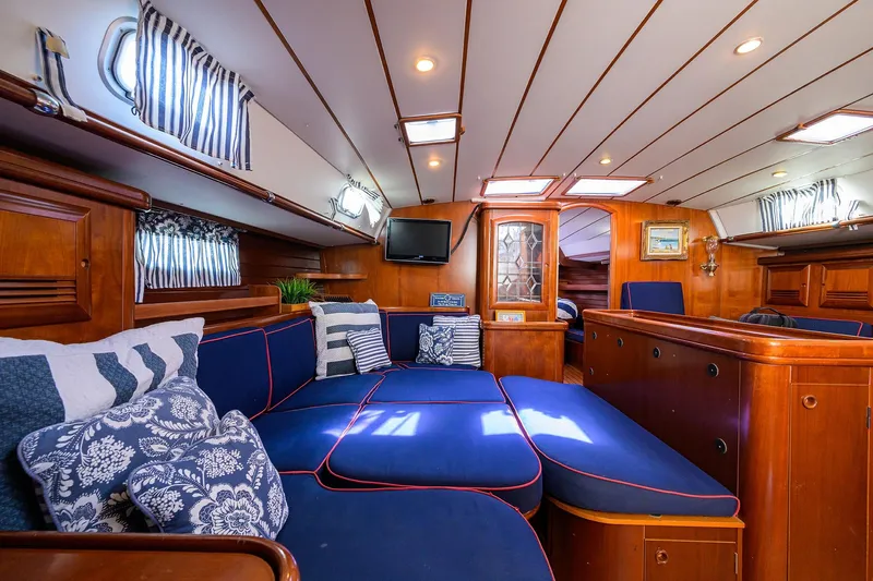 Windigo Yacht Photos Pics Luxurious interior of 2003 Beneteau 50 yacht with blue seating and wooden accents.