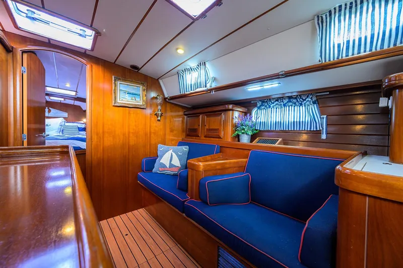 Windigo Yacht Photos Pics Luxurious interior of 2003 Beneteau 50 yacht with blue seating and wooden finishes.