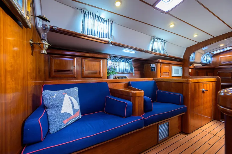 Windigo Yacht Photos Pics Luxurious interior of 2003 Beneteau 50 yacht with blue seating and wooden finishes.