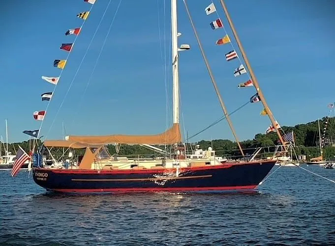 Indigo Yacht Photos Pics Sailboat Pacific Seacraft 40, 2005 model, adorned with flags, anchored on a sunny day.