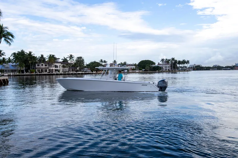 Bandit Yacht Photos Pics 2018 Jupiter 38 FS boat cruising on a calm waterfront with palm trees and houses.