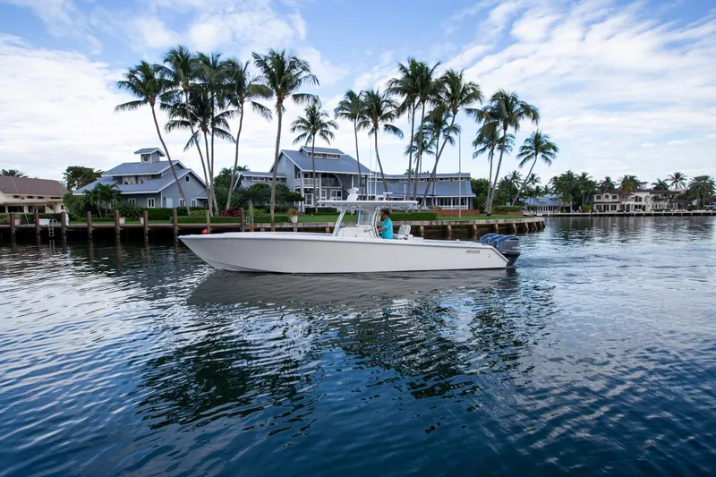 Bandit Yacht Photos Pics 2018 Jupiter 38 FS boat on calm water with palm trees and houses in the background.