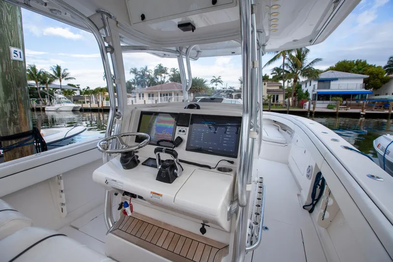 Bandit Yacht Photos Pics 2018 Jupiter 38 FS boat cockpit with advanced navigation system, docked near waterfront homes.