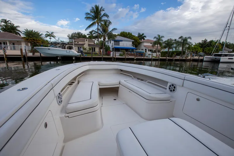 Bandit Yacht Photos Pics 2018 Jupiter 38 FS boat interior with white seating, docked near waterfront homes.
