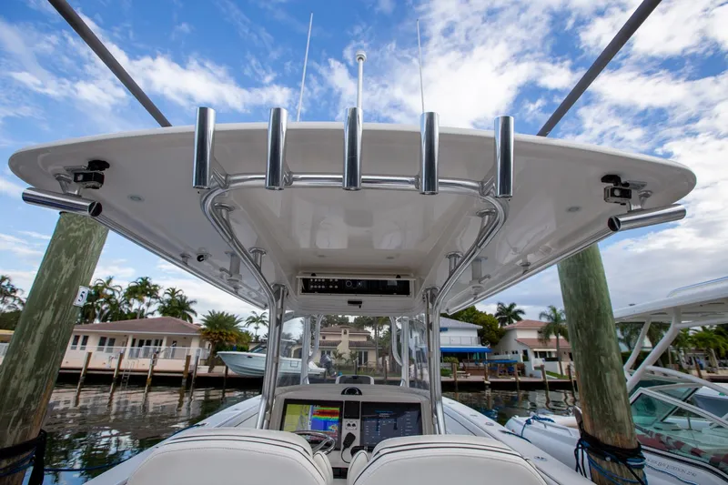 Bandit Yacht Photos Pics 2018 Jupiter 38 FS boat console with fishing rod holders, docked by waterfront homes.