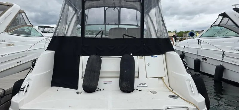  Yacht Photos Pics 2009 Sea Ray 310 Sundancer docked, rear view with protective covers and fenders.