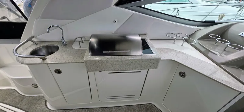  Yacht Photos Pics 2009 Sea Ray 310 Sundancer boat kitchenette with sink, grill, and cup holders.