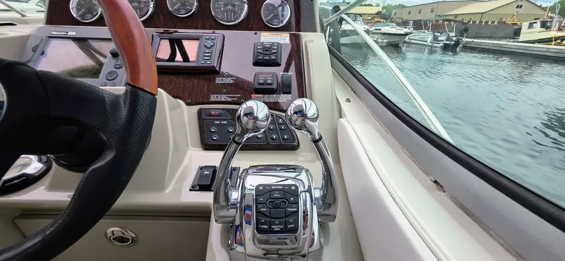  Yacht Photos Pics 2009 Sea Ray 310 Sundancer helm with controls and gauges, docked by the water.