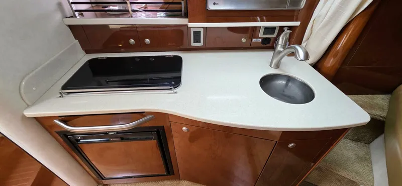  Yacht Photos Pics 2009 Sea Ray 310 Sundancer galley with sink, stove, and cabinetry.