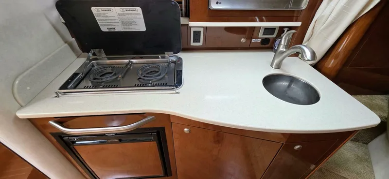  Yacht Photos Pics 2009 Sea Ray 310 Sundancer galley with stove, sink, and compact fridge.