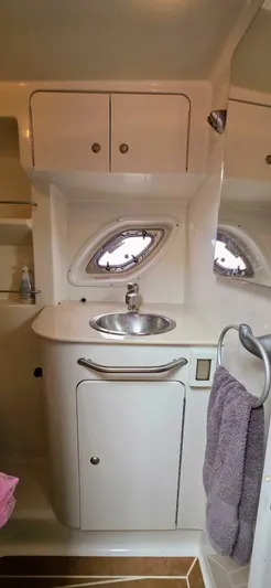  Yacht Photos Pics 2009 Sea Ray 310 Sundancer bathroom with sink, cabinet, and porthole window.