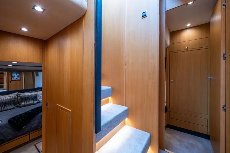 Reset Yacht Photos Pics Interior of 2015 Fairline 78 Squadron yacht with wooden paneling and carpeted stairs.