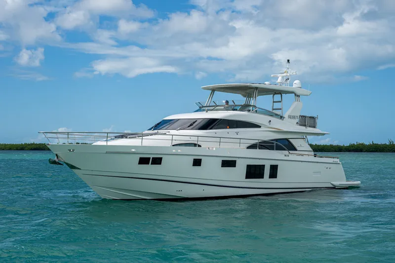 Reset Yacht Photos Pics Luxury 2015 Fairline 78 Squadron yacht cruising on turquoise waters under a blue sky.
