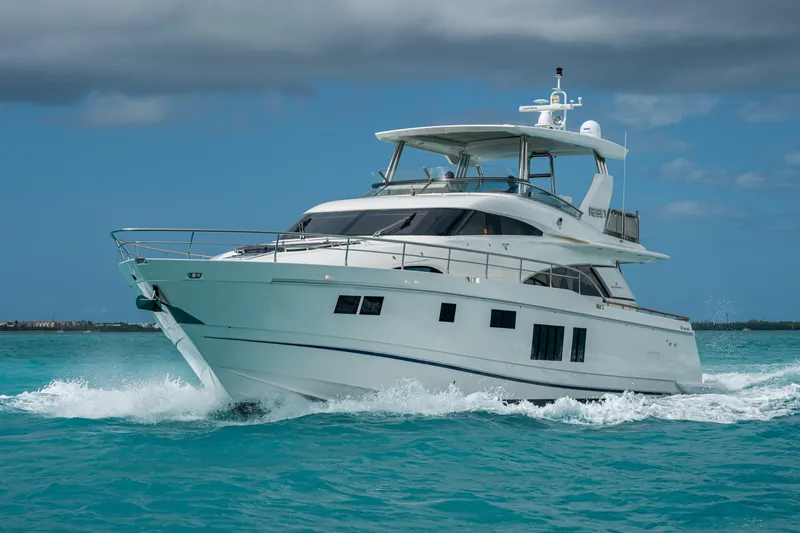 Reset Yacht Photos Pics Luxury 2015 Fairline 78 Squadron yacht cruising on turquoise waters under cloudy skies.