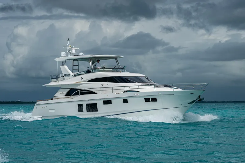 Reset Yacht Photos Pics Luxury 2015 Fairline 78 Squadron yacht cruising on turquoise waters under cloudy skies.