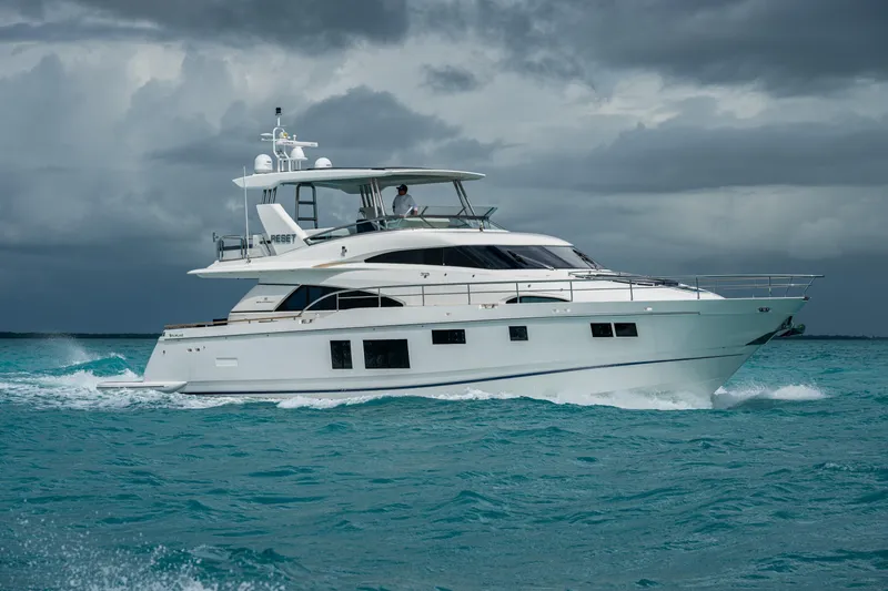 Reset Yacht Photos Pics Luxurious 2015 Fairline 78 Squadron yacht cruising on turquoise waters under cloudy skies.
