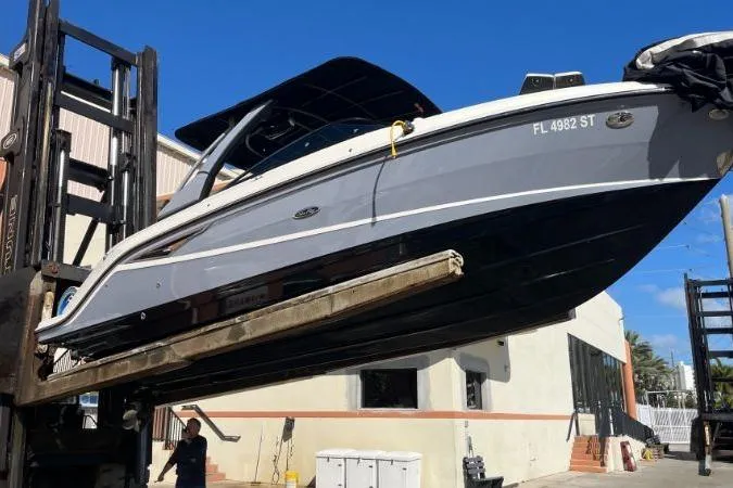 Lowest Priced 280slx In Mint Condition Yacht Photos Pics 2021 Sea Ray SLX 280 boat on forklift, outdoor storage, clear blue sky.