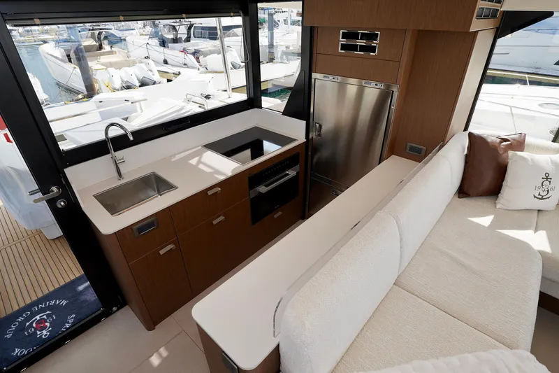  Yacht Photos Pics Modern yacht kitchen interior with sleek design, featuring a sink, stove, and comfortable seating. Prestige F5.7, 2025.