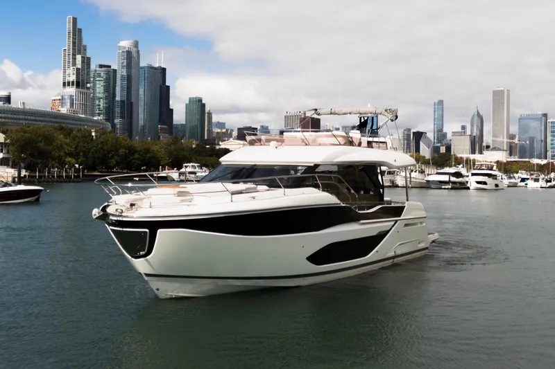  Yacht Photos Pics Luxury Prestige F5.7 yacht cruising in urban harbor, 2025 model, city skyline backdrop.