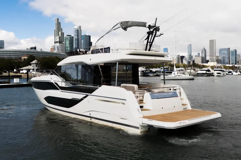  Yacht Photos Pics Luxury 2025 Prestige F5.7 yacht cruising near city skyline and marina.