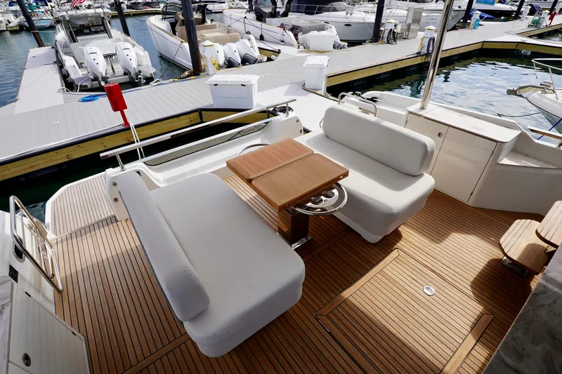  Yacht Photos Pics Luxurious Prestige F5.7 yacht deck with elegant seating and wooden flooring, docked at marina.