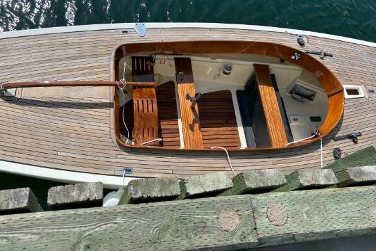 2010 Rustler 24 sailboat with wooden deck, docked on calm water.