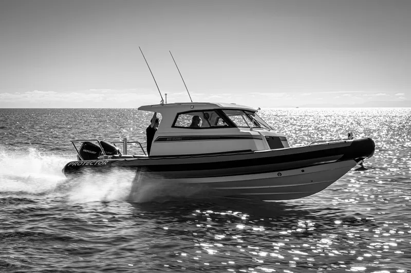 Protector Yacht Photos Pics 2020 Protector 310 Targa boat cruising on sunlit ocean waters.