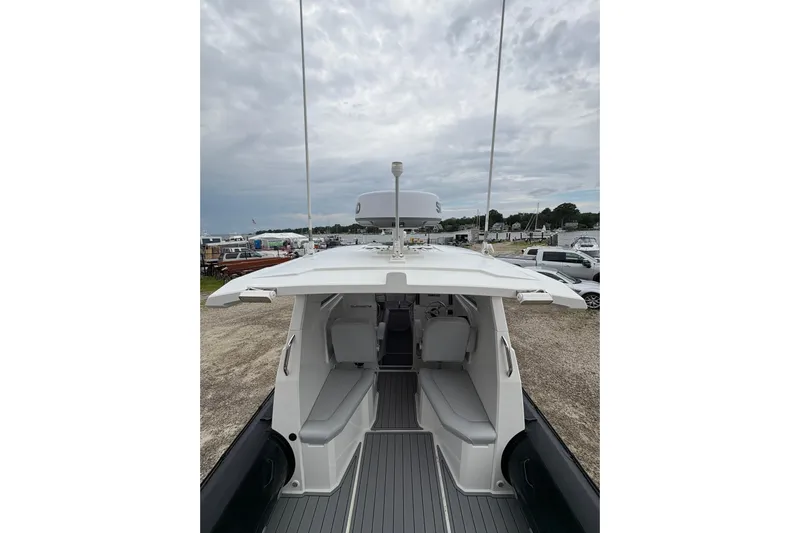 Protector Yacht Photos Pics 2020 Protector 310 Targa boat interior with seating, docked under cloudy skies.