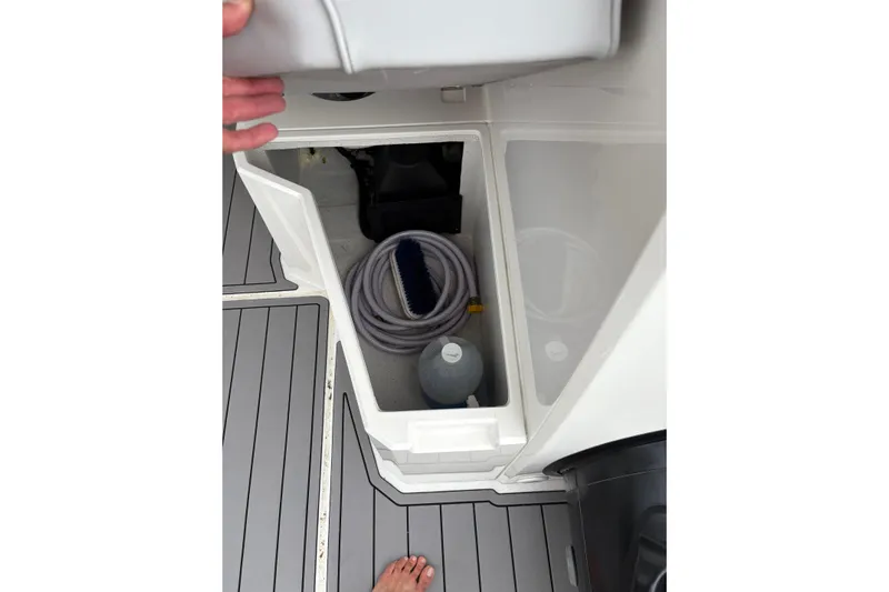 Protector Yacht Photos Pics Storage compartment on 2020 Protector 310 Targa boat with hose and cleaning supplies.