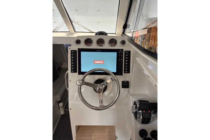 Protector Yacht Photos Pics Cockpit of 2020 Protector 310 Targa with Simrad navigation system and steering wheel.