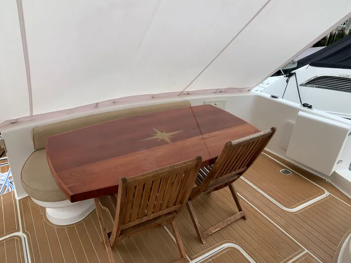  Yacht Photos Pics Luxury 2004 Ocean Yachts 57 Odyssey deck with elegant wooden dining table and chairs.