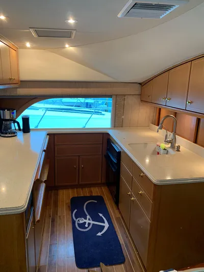  Yacht Photos Pics Luxurious kitchen interior of 2004 Ocean Yachts 57 Odyssey with wood cabinetry and modern appliances.