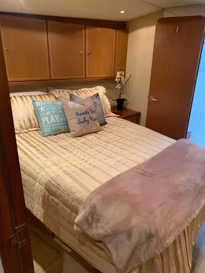  Yacht Photos Pics Cozy bedroom in 2004 Ocean Yachts 57 Odyssey with decorative pillows and wooden cabinets.